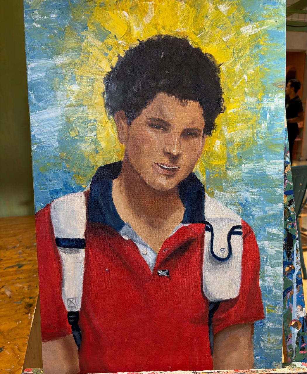 Retrato al óleo de Carlo Acutis con camiseta roja y mochila, sobre un fondo de destellos dorados y azules