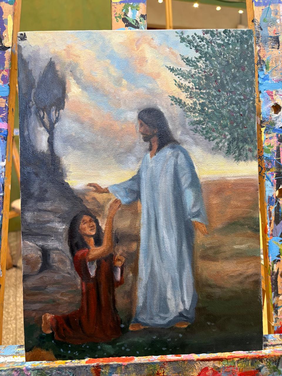 Óleo de Jesús tendiendo la mano a una mujer arrodillada en un paisaje al atardecer